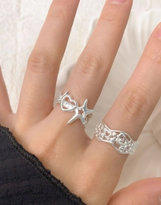 Close-up of S925 sterling silver rings with hollow heart and star designs on hand