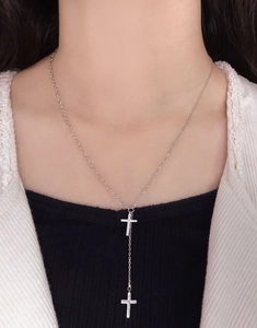Detail of silver S925 cross tassel Y-necklace with sparkling zircons on a female model