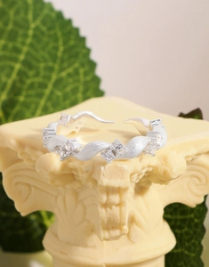 Detailed view of s925 silver wavy ring with zircons on elegant stone pedestal