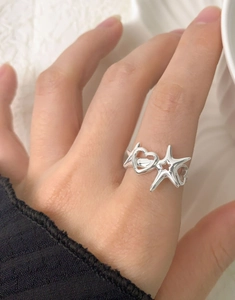 Detailed view of S925 sterling silver ring with hollow star and heart worn on index finger
