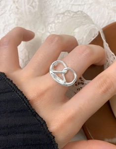 Detailed view of S925 sterling silver pretzel knot ring worn on a finger