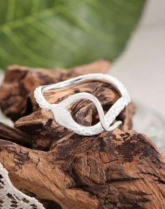 Macro shot of silver snake ring featuring detailed scales on vintage wood background