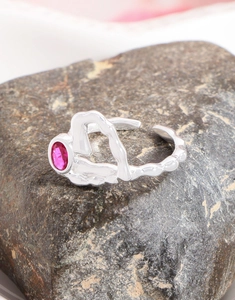 Détail d'une bague en argent S925 à texture de lave irrégulière avec une pierre de zircon rose