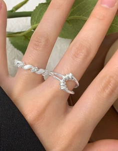 Detail of twisted pavé zircon and double-layer woven silver rings on model hand