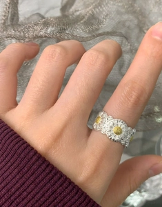 Close-up of S925 sterling silver daisy ring with yellow floral relief detail