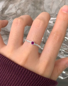 Detail of S925 silver ring with rose pink zircon and irregular ripple texture on hand