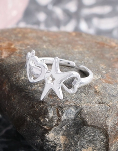 Macro detail of S925 sterling silver starfish ring with heart cutouts on a natural stone