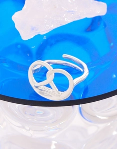 Close-up of S925 sterling silver pretzel heart ring on glass with ice texture