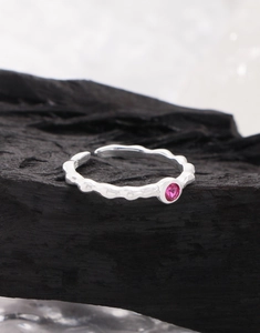 Macro shot of S925 sterling silver ring featuring a wave band and pink round zircon