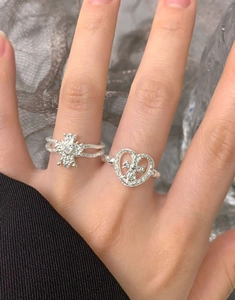 Detailed view of silver heart and cross rings with hammered texture and fine crystals