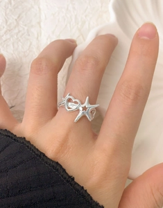 Detailed view of S925 silver ring featuring hollow heart and star designs on hand