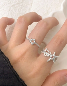 Close-up of S925 silver rings featuring hollow heart and star designs on hand