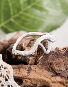 Macro shot of S925 sterling silver snake ring with detailed scales on wood