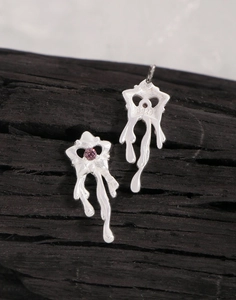 Gros plan du poinçon S925 et du zircon rose sur les boucles d'oreilles cœur en métal liquide