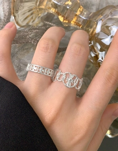 Macro detail of S925 sterling silver rings with gothic cross and hammered heart texture