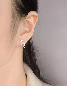 Gros plan sur boucle d'oreille en argent S925 design fluide avec zircon violet