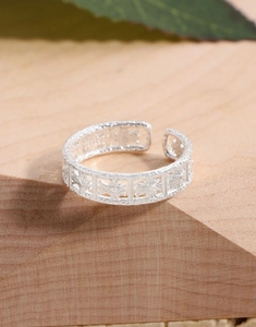 Close-up of S925 sterling silver ring featuring hollowed floral patterns and hammered texture