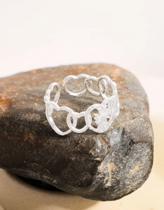 Detailed view of S925 silver heart-link ring with hand-hammered texture on raw stone