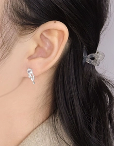 Gros plan d'une boucle d'oreille en argent S925 avec zircon violet sur l'oreille