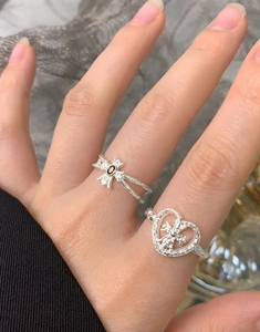 Detailed view of S925 silver hammered heart ring and cross ring with red gemstone