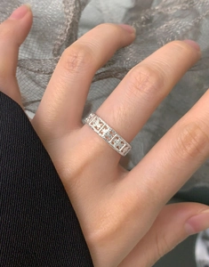 Detailed close-up of a hollow silver ring with a vintage lattice pattern and floral motifs