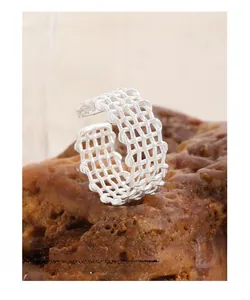 Detailed close-up of S925 sterling silver mesh woven ring on a textured rock surface