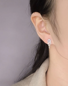 Gros plan d'une boucle d'oreille en métal liquide avec pierre précieuse violette