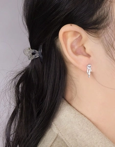 Vue macro détaillée de la boucle d'oreille en argent S925 avec zircon violet sur l'oreille