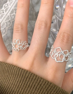 Close-up of S925 sterling silver hollow curved and wide braided rings on model's hand