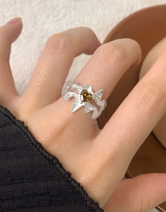 Détail d'une bague en argent S925 avec zircon brun en forme de cœur sur un doigt