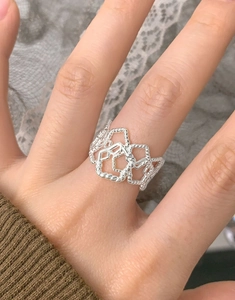 Macro view of S925 sterling silver ring featuring hollow geometric weave texture