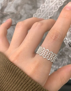 Detailed view of women's S925 sterling silver multilayer woven mesh ring worn on finger