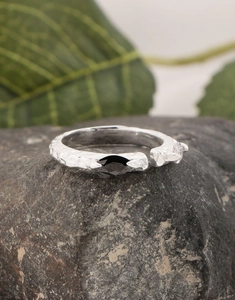 Detail of silver S925 snake texture ring with black marquise zircon on a dark stone
