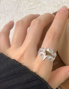 Détail de bague en argent S925 avec texture fondue et zircone cœur marron sur le doigt