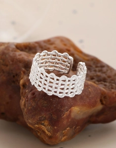 Macro shot of silver woven mesh texture and hollow design on a S925 sterling silver ring