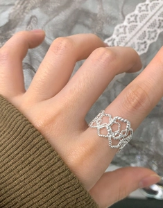 Detailed shot of an irregular hollow textured S925 sterling silver ring worn on hand