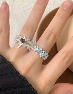 Détail de bagues irrégulières en argent avec zircon en cœur et texture gothique