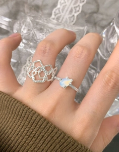 Close-up of S925 silver irregular textured hollow ring and opal stone ring on finger