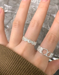 Detail of S925 silver rings with braided texture and hollow heart pattern on finger