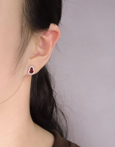 Close-up of S925 silver gourd earring with red agate inlay and zircon stones on ear