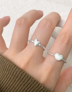 Close-up of S925 sterling silver heart rings with frosted texture and twisted band