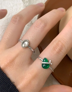 Detail of S925 silver rings with green chalcedony gourd and oval gemstone on finger