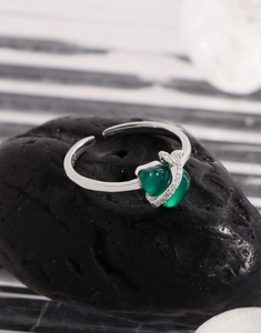 Macro detail of S925 sterling silver stamp and green heart gemstone on adjustable ring