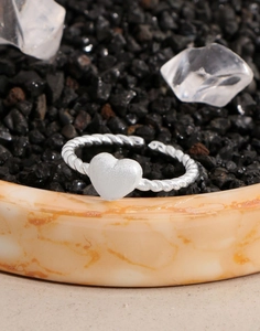 Detailed macro view of silver twisted rope ring featuring a matte heart-shaped design