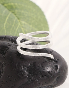 Close-up of S925 sterling silver ring with textured snake skin pattern on volcanic stone