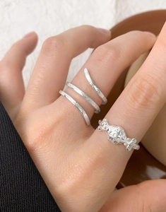 Close-up of S925 silver rings set with snake texture and candy design on hand