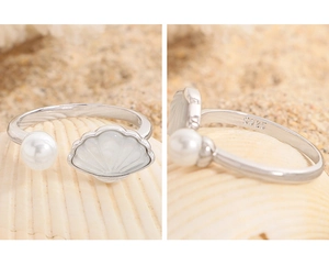 Dettaglio macro di anello in argento S925 con motivo a conchiglia bianca e perla lucida