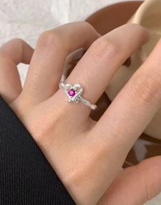 Close-up of S925 silver ring featuring a pink zircon heart and wavy band on model hand