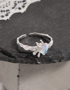 Macro detail of S925 silver lava texture heart moonstone ring on stone background