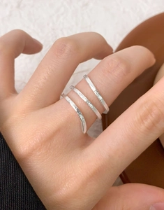 Macro shot of silver triple-layered wrap ring with textured rock finish on hand